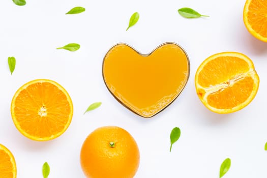 Heart shape glass of fresh orange juice with orange fruit on white background. Top view 