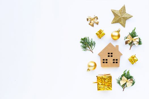 Merry Christmas and Happy Holidays, Miniature house with Christmas composition. gifts, pine branches and decorations on white background. Copy space