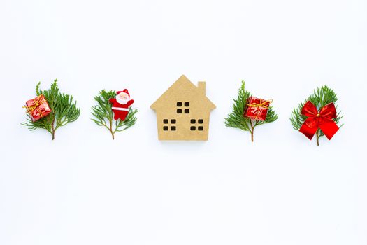 Merry Christmas and Happy Holidays, Miniature house with Christmas composition. gifts, pine branches and decorations on white background. Copy space