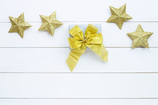 Merry Christmas and Happy Holidays, Christmas composition. gift box, golden stars on white wooden background. Top view