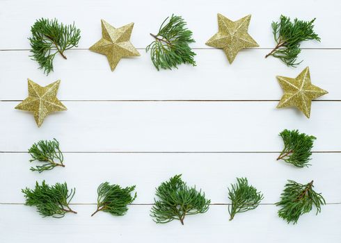 Merry Christmas and Happy Holidays, Christmas composition. golden stars, pine branches on white wooden background. Top view