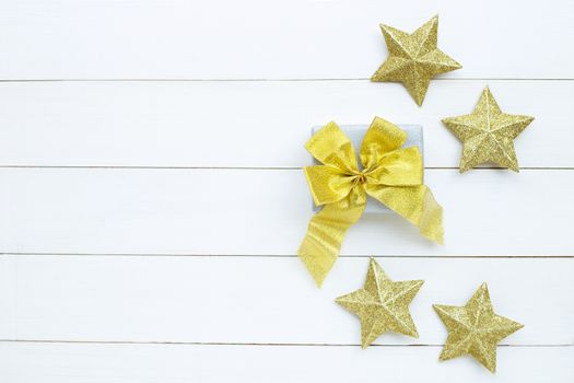 Merry Christmas and Happy Holidays, Christmas composition. gift box, golden stars on white wooden background. Top view