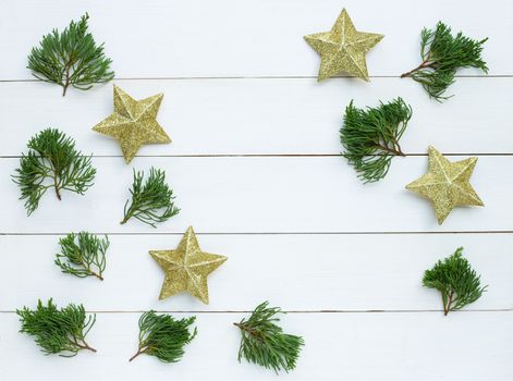 Merry Christmas and Happy Holidays, Christmas composition. golden stars, pine branches on white wooden background. Top view