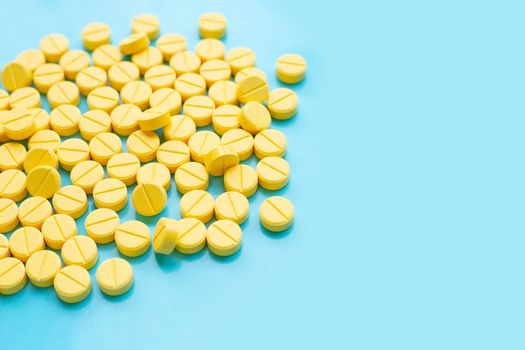 Yellow tablets of Paracetamol on blue background.  Copy space