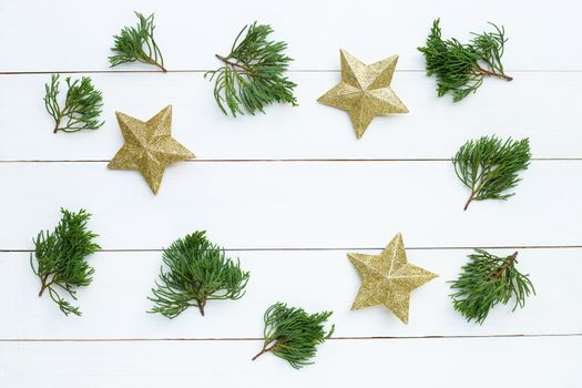 Merry Christmas and Happy Holidays, Christmas composition. golden stars, pine branches on white wooden background. Top view