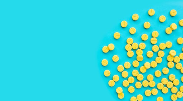 Yellow tablets of Paracetamol on blue background.  Copy space
