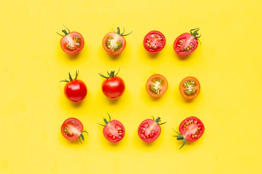 Fresh tomatoes, whole and half cut isolated on yellow background. Top view
