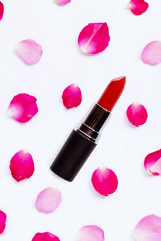 Lipstick with rose petals isolated on white background. 