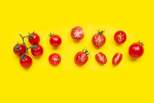 Fresh tomatoes, whole and half cut isolated on yellow background. Top view