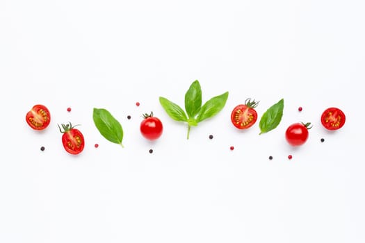 Fresh  cherry tomatoes with basil leaves and different type of peppercorns on white background. Top view