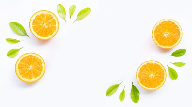 Frame made of fresh orange fruit with green leaves on white background
