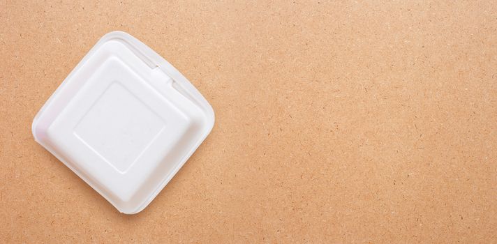 Foam food container on plywood background.  Copy space