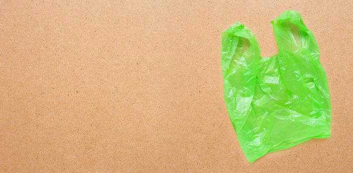 Green plastic bag on plywood background.  Copy space