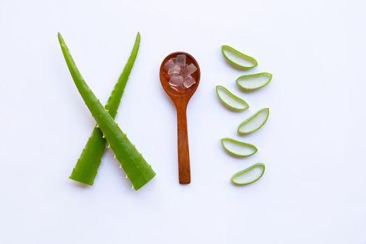 Aloe vera gel in a wooden spoon with aloe vera leaves and slices on  white background.