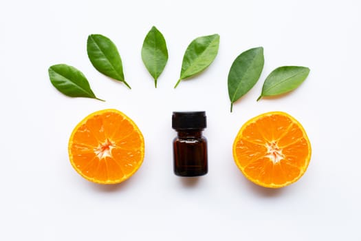 Orange essential oil with fresh fruits on white background.