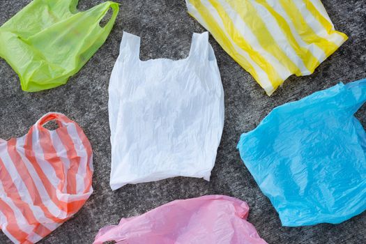 Colorful plastic bags on cement floor background.