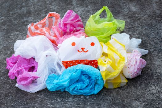 Colorful plastic bags on dark cement floor background