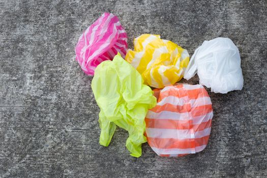 Colorful plastic bags on cement floor background.