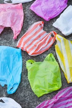 Colorful plastic bags on cement floor background.