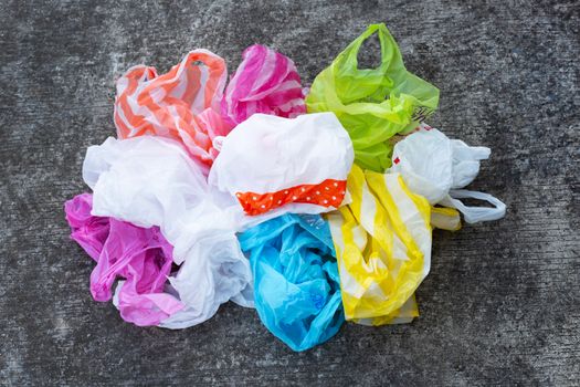 Colorful plastic bags on dirty cement floor background.