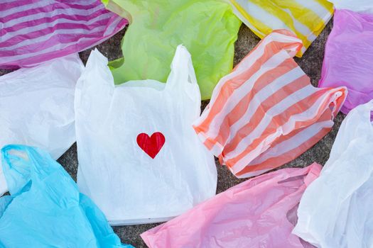 Colorful plastic bags on cement floor background