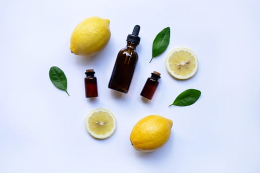 Fresh lemon with lemon essential oil on a white background.