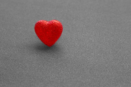 The red heart shape on dark grey glitter background  in love concept for valentines day. Copy space