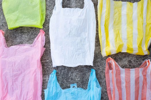 Colorful plastic bags on cement floor background.
