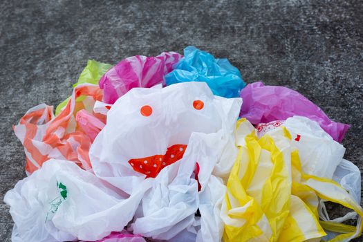 Colorful plastic bags on cement floor background.