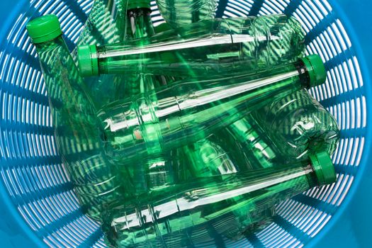 Plastic bottles in blue waste basket.