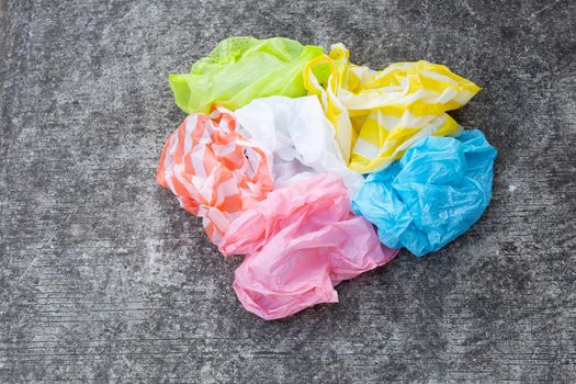 Colorful plastic bags on cement floor background.