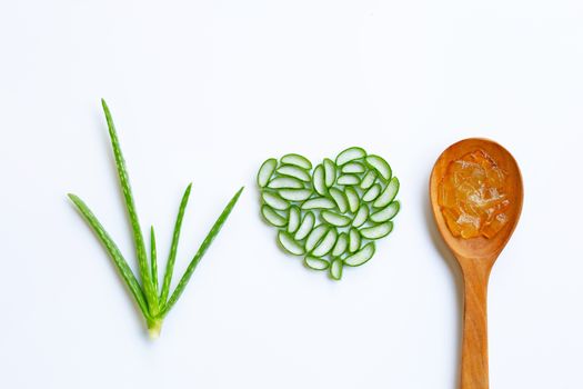 Aloe vera gel on wooden spoon with aloe vera slices heart shaped on white background