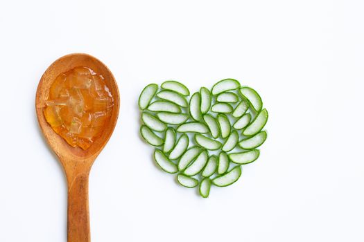 Aloe vera gel on wooden spoon with aloe vera slices heart shaped on white background