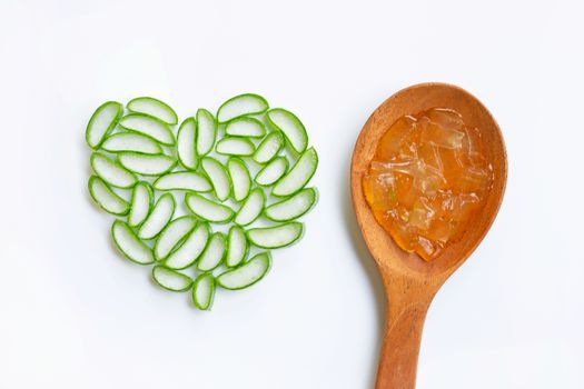 Aloe vera gel on wooden spoon with aloe vera slices heart shaped on white background