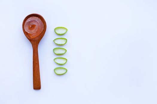 Aloe vera gel on wooden spoon with aloe vera slices on white background. Copy space