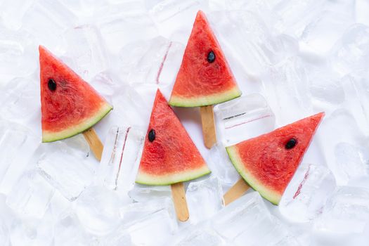Sweet watermelon slice popsicles on ice background