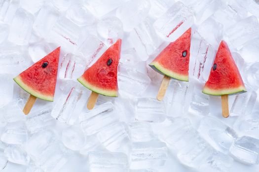 Sweet watermelon slice popsicles on ice background
