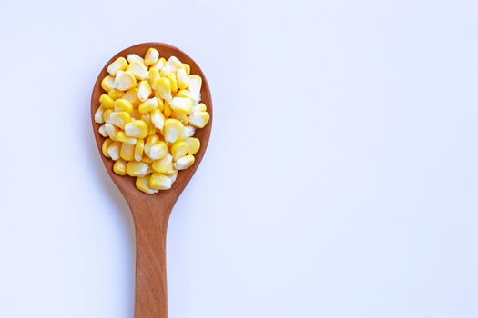 Corn seeds on wooden spoon, white background