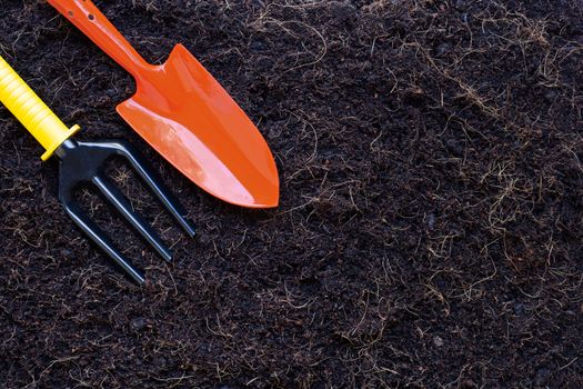 Garden shovel and fork on soil with coconut shell's hair for agriculture.