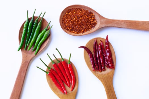 Hot chili pepper on  wooden spoon, white background.