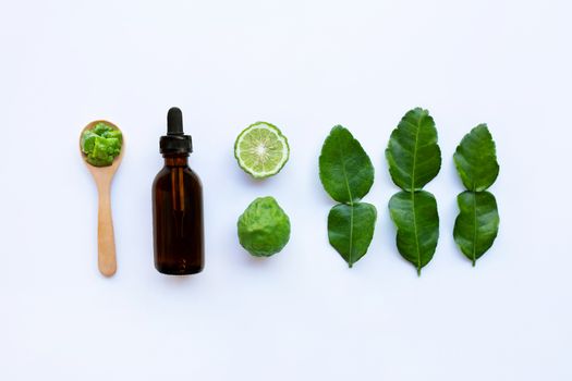 Bottle of essential oil and  fesh Bergamot fruit with leaves isolated on white background.