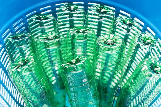 Plastic bottles in blue waste basket.