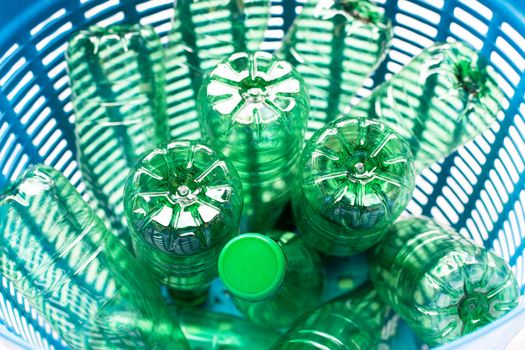 Plastic bottles in blue waste basket.