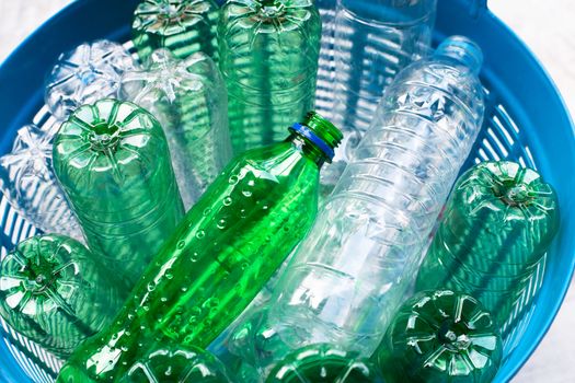 Plastic bottles in blue waste basket.