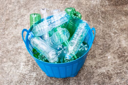 Plastic bottles in blue waste basket.