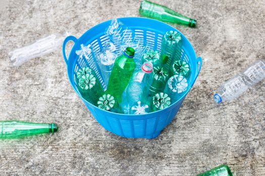 Plastic bottles in blue waste basket.