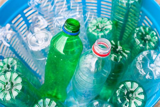 Plastic bottles in blue waste basket.