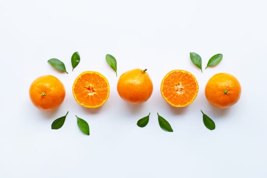 Orange fruits and green leaves on a white background. Top view