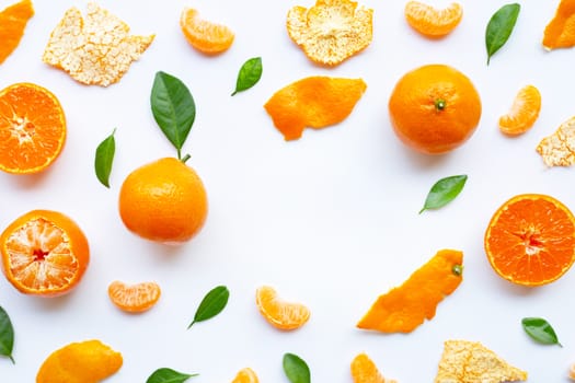 Orange fruits and green leaves on a white background. Copy space