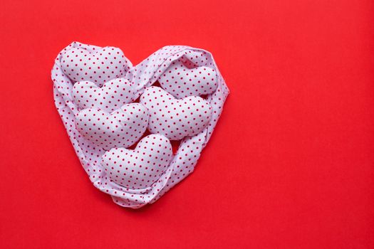 Red dots on white heart shape, Valentine's hearts on red background, Top view with copy space